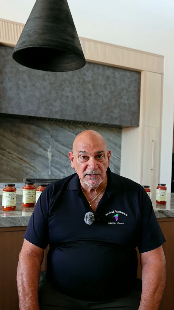 Michael Martorana in his kitchen with jars of his Sicilian sauce